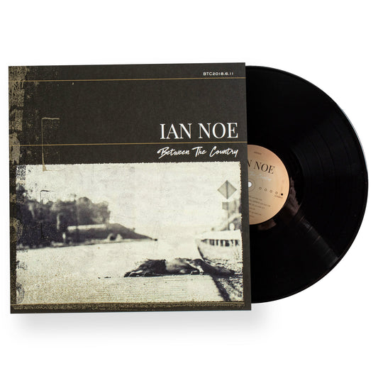 Vinyl record with cover featuring 'Ian Noe' and 'Between The Country' on a white background